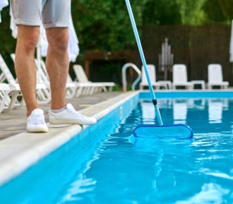 Cleaning the pool. A service person cleaning the swimming pool and looking busy